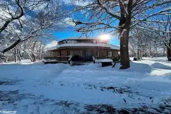 Snow covered rear of property with covered porch