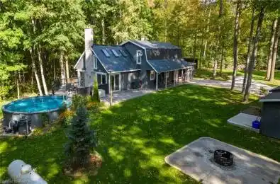 Rear view of property featuring a lawn, a fire pit, and a patio area