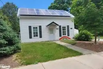 View of front of home featuring a front yard and solar panels
