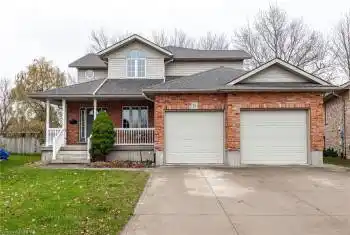 View of front of home with a porch, a garage, and a front lawn