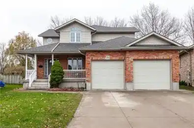 View of front of home with a porch, a garage, and a front lawn